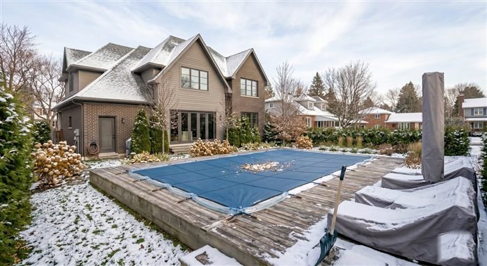 Piscine couverte d'une bâche bleue de sécurité en début d'hiver